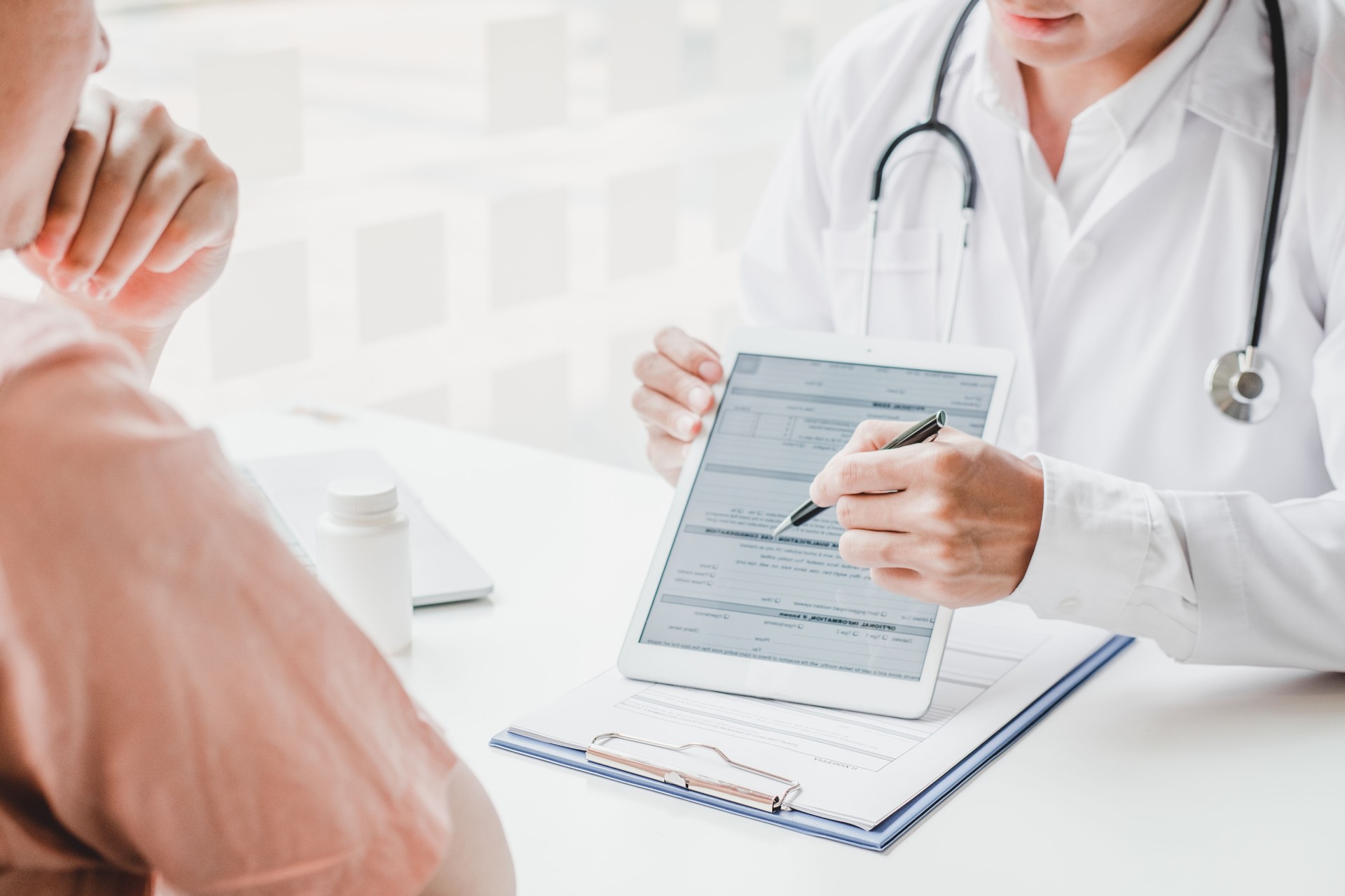 Doctors and patients consulting and diagnostic examining sit and talk. At the table near the window in the hospital medicine concept
